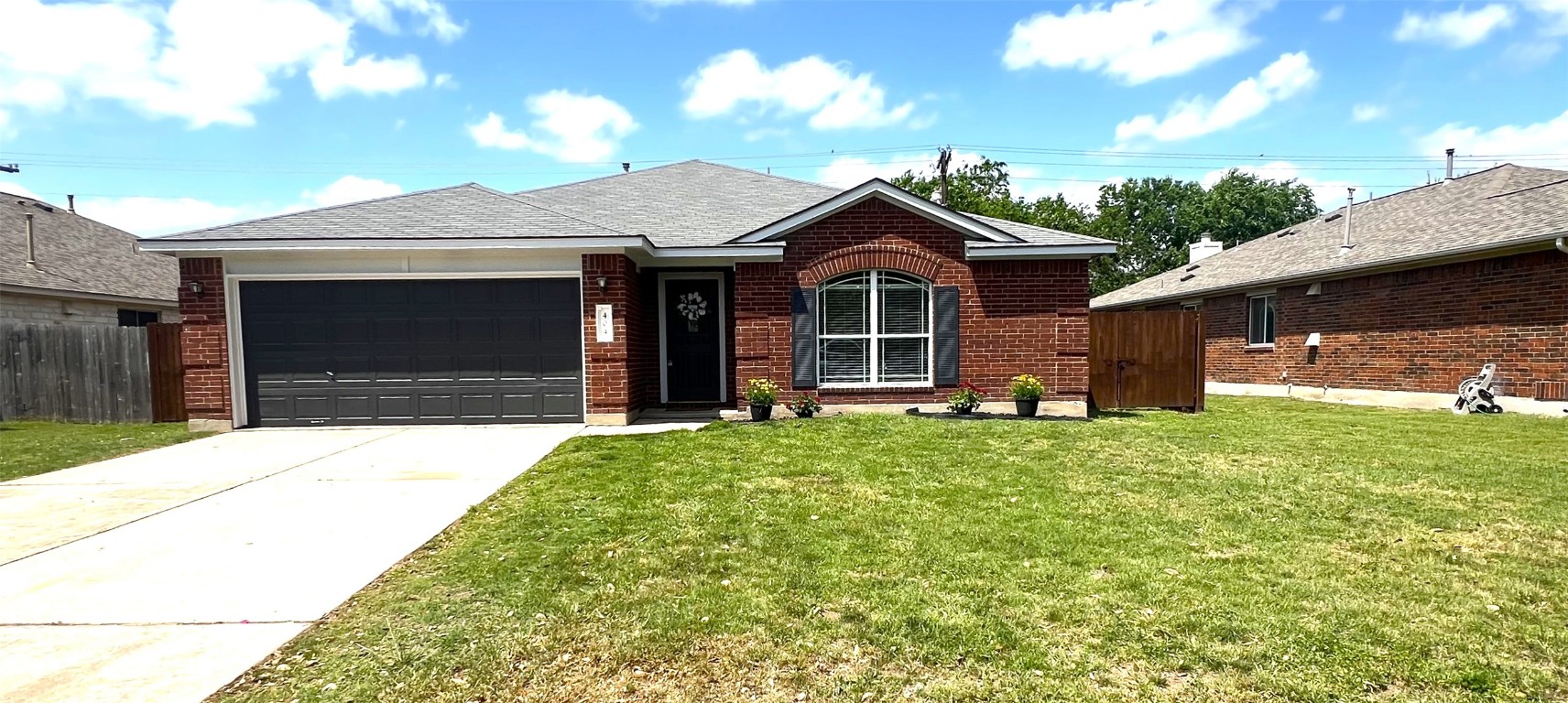 404 Patton Cove Bastrop, TX 78602 - Photo 5 of 40 Single story home with an attached garage, brick siding, a front yard, and concrete driveway