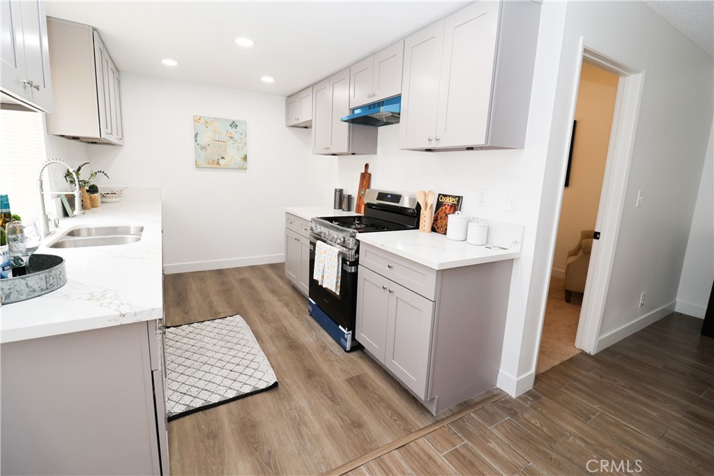 1161 Blue Ridge Lane Colton, CA 92324 - Photo 7 of 36 a kitchen with a sink stove and wooden floor