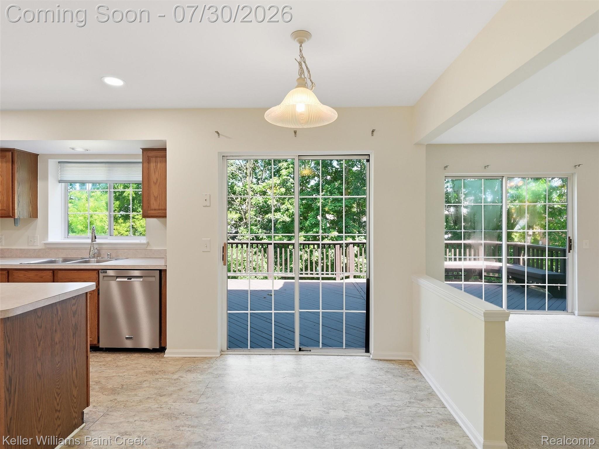 543 Arlington Drive Rochester, MI 48307 - Photo 16 of 59 Kitchen area featuring wood-finish cabinetry, stainless steel dishwasher, and a sink with a window overlooking exterior greenery