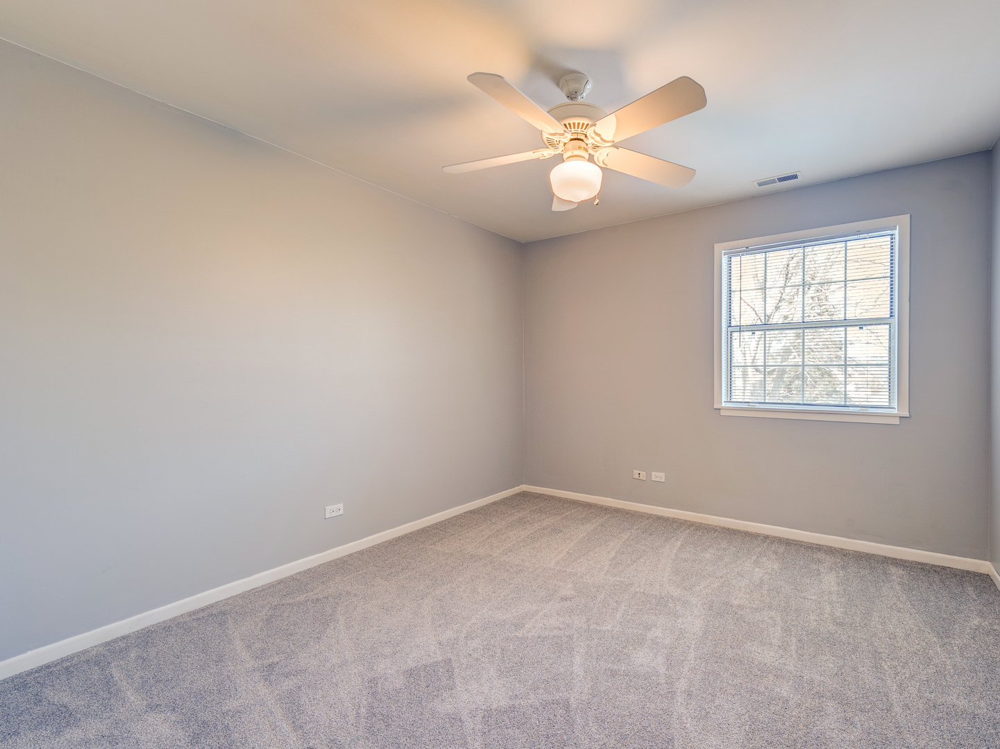 15 Gant Circle, Unit E Streamwood, IL 60107 - Photo 11 of 18 an empty room with a chandelier fan and windows