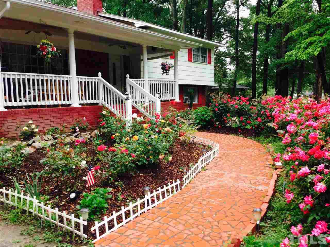 4713 Greenbrier Road Raleigh, NC 27603 - Photo 3 of 9 a view of a house with a flower garden and flower garden