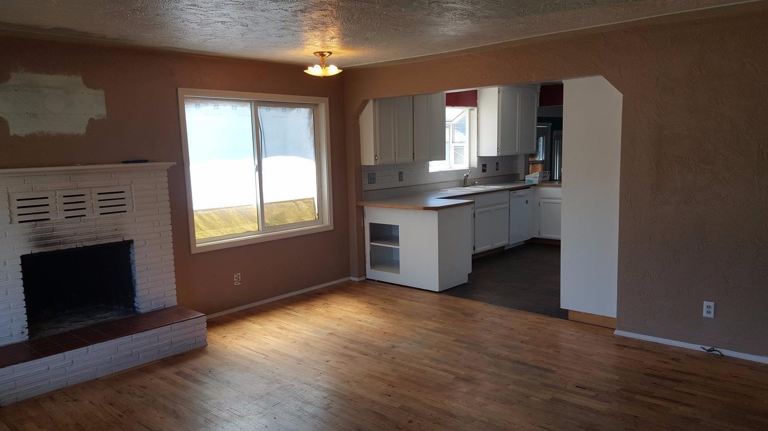 215 Maple Street Central Point, OR 97502 - Photo 6 of 17 a kitchen with kitchen island granite countertop a stove a sink and a wooden floor