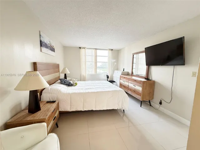 a bedroom with bed and flat screen tv