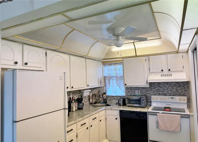 a kitchen with stainless steel appliances granite countertop a refrigerator sink and cabinets