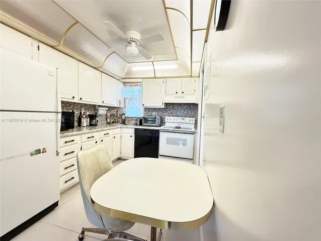 a kitchen with white cabinets and white appliances