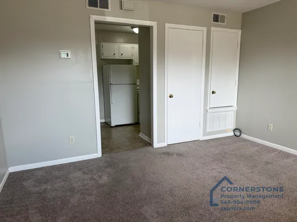 an empty room with closet and mirrors