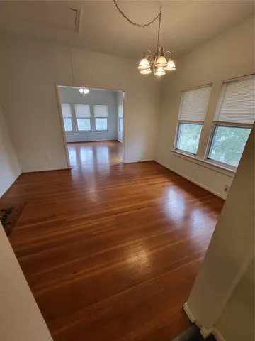 a view of a room with wooden floor and chandelier