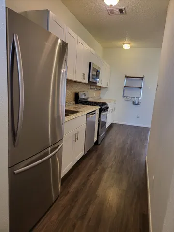a kitchen with stainless steel appliances a refrigerator and a stove top oven