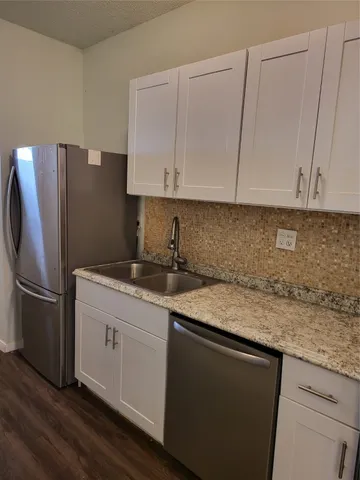 a kitchen with stainless steel appliances granite countertop a refrigerator sink and cabinets