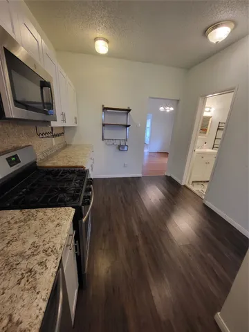 a kitchen with wooden floors and appliances