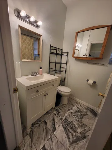 a bathroom with a toilet sink and mirror