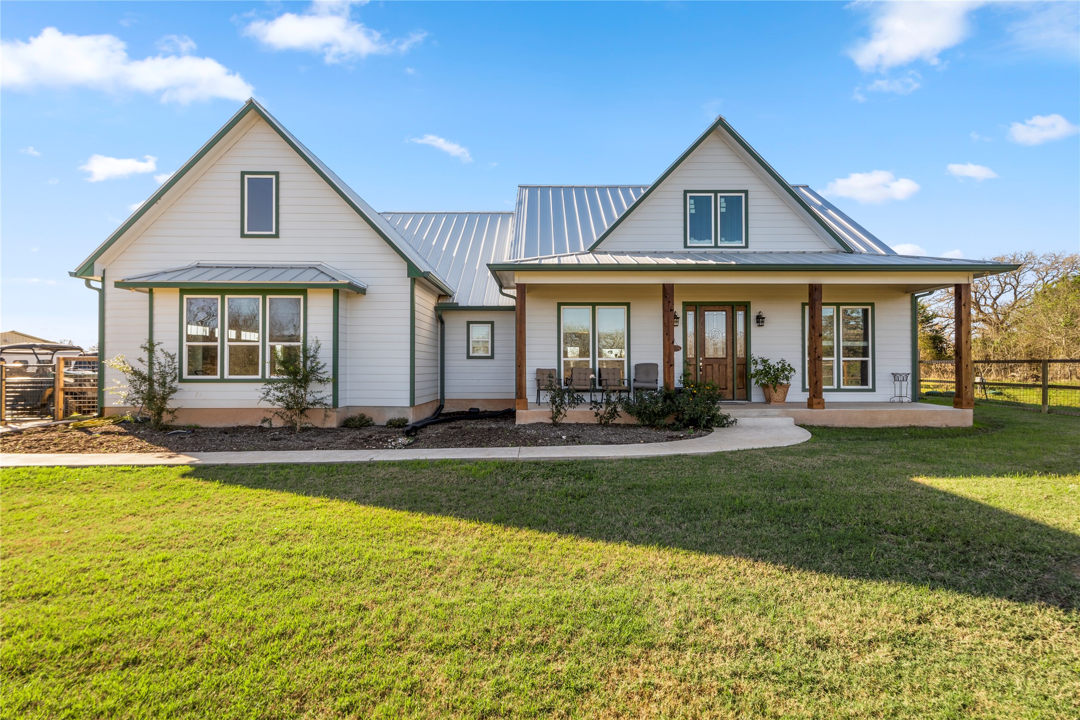 1434 Antioch Road Paige, TX 78659 - Photo 4 of 40 Front View of property featuring a porch and a standing metal seam roof & sidewalk