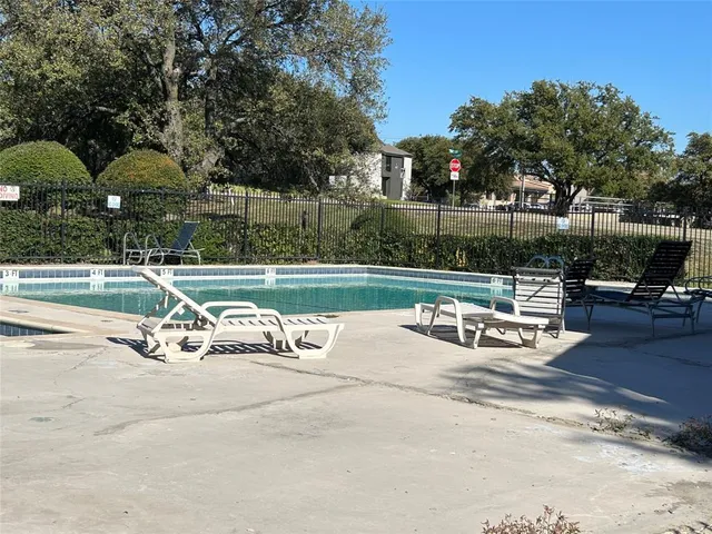 a view of a tennis ground with trees in the background