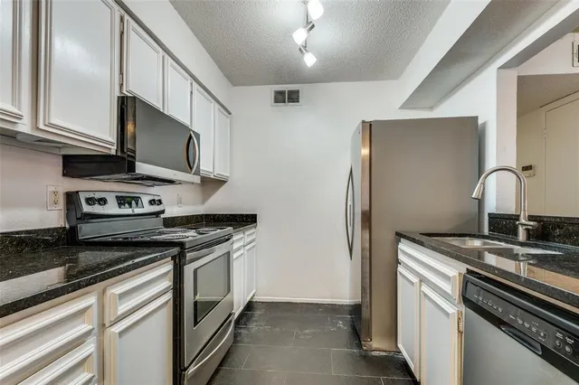 a kitchen with stainless steel appliances granite countertop a stove and a refrigerator