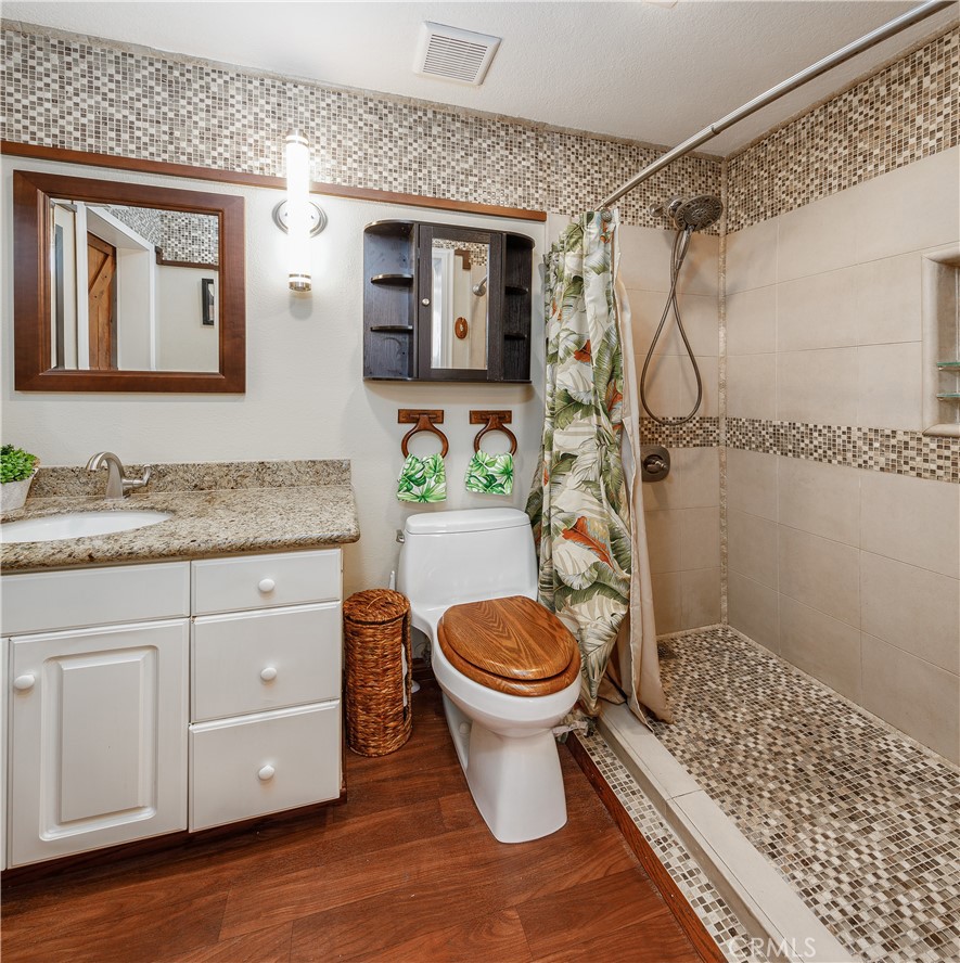 20331 Bluffside Circle, Unit A411 Huntington Beach, CA 92646 - Photo 11 of 44 a bathroom with a granite countertop toilet sink and shower