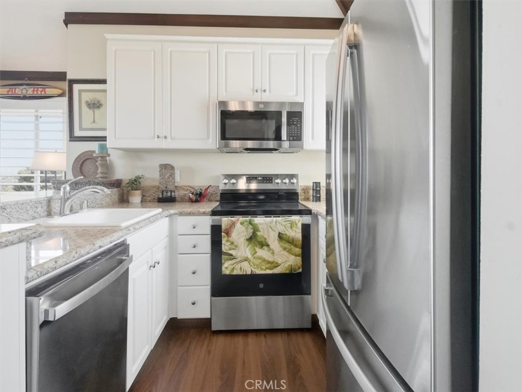 20331 Bluffside Circle, Unit A411 Huntington Beach, CA 92646 - Photo 21 of 44 Bright and airy chef’s kitchen with modern appliances, illuminated by natural light streaming through the kitchen window.