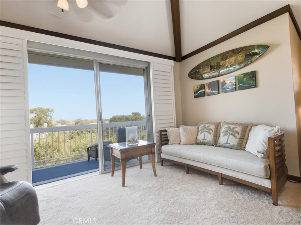 20331 Bluffside Circle, Unit A411 Huntington Beach, CA 92646 - Photo 24 of 44 North-facing living area with sliding custom plantation shutters, vaulted ceilings, and ornate wood beams, offering panoramic views for miles.