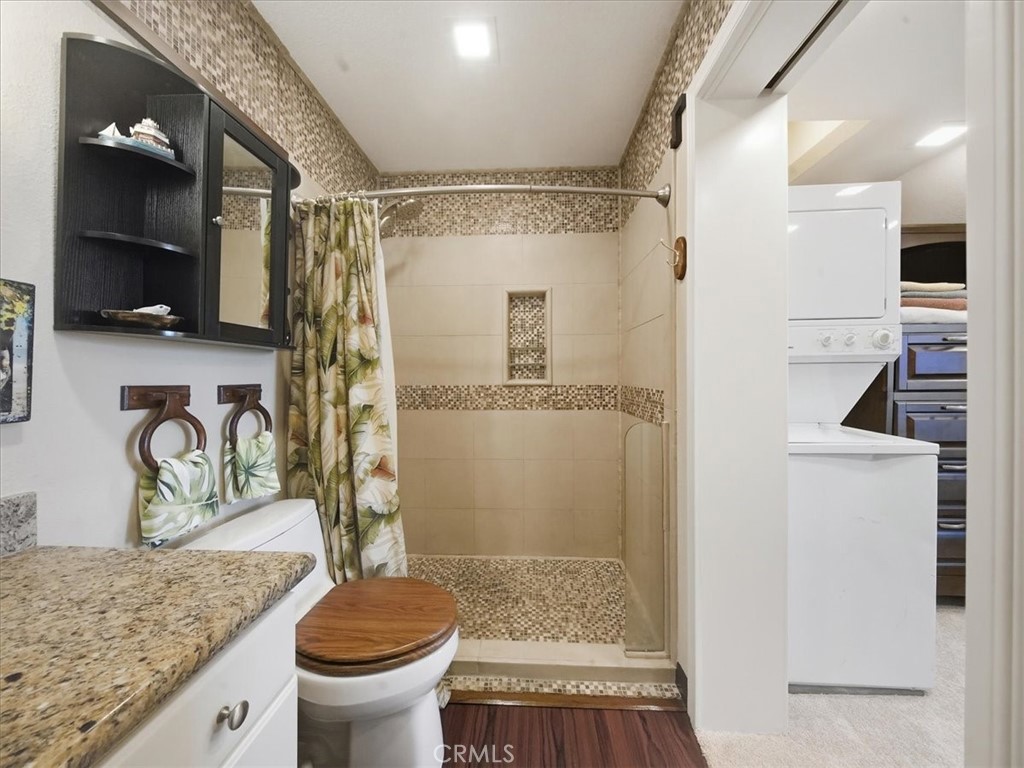 20331 Bluffside Circle, Unit A411 Huntington Beach, CA 92646 - Photo 28 of 44 a bathroom with a granite countertop sink toilet and shower