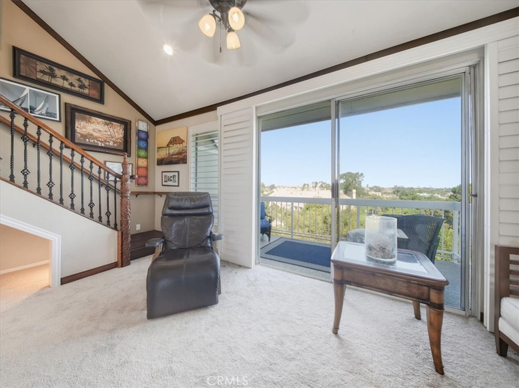 20331 Bluffside Circle, Unit A411 Huntington Beach, CA 92646 - Photo 7 of 44 Penthouse living area with sliding glass doors, plantation shutters, and breathtaking vista views stretching for miles