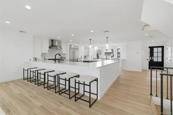 a large white kitchen with lots of counter space wooden floor and appliances