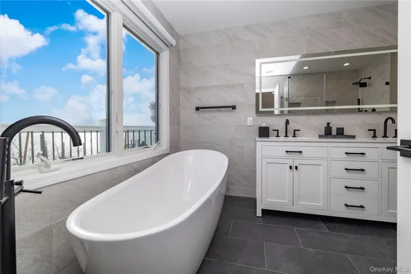 a bathroom with a bathtub sink and mirror