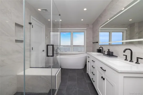 a bathroom with a double vanity sink a mirror a bathtub and shower