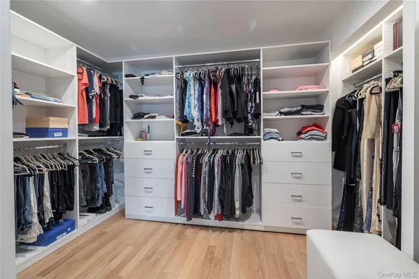 a view of walk in closet with clothes and shoes
