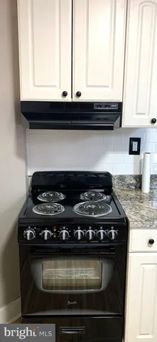 a stove top oven sitting inside of a kitchen