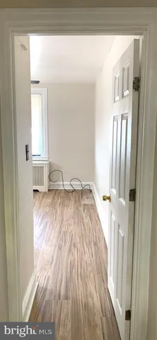 a view of a bedroom with wooden floor and front door