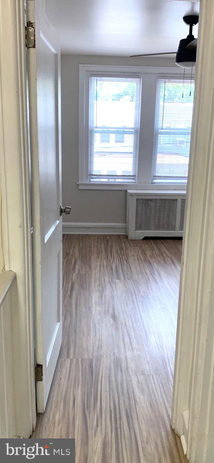 252 Rosemar Street, Unit 2 Philadelphia, PA 19120 - Photo 4 of 22 a view of an empty room with wooden floor and a window