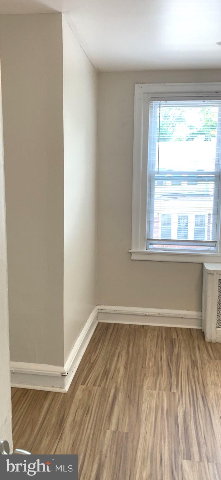 252 Rosemar Street, Unit 2 Philadelphia, PA 19120 - Photo 5 of 22 an empty room with wooden floor and windows