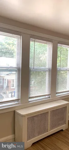 a living room with kitchen island wooden floor and a large window
