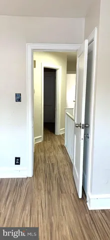 a view of a hallway with wooden floor and closet