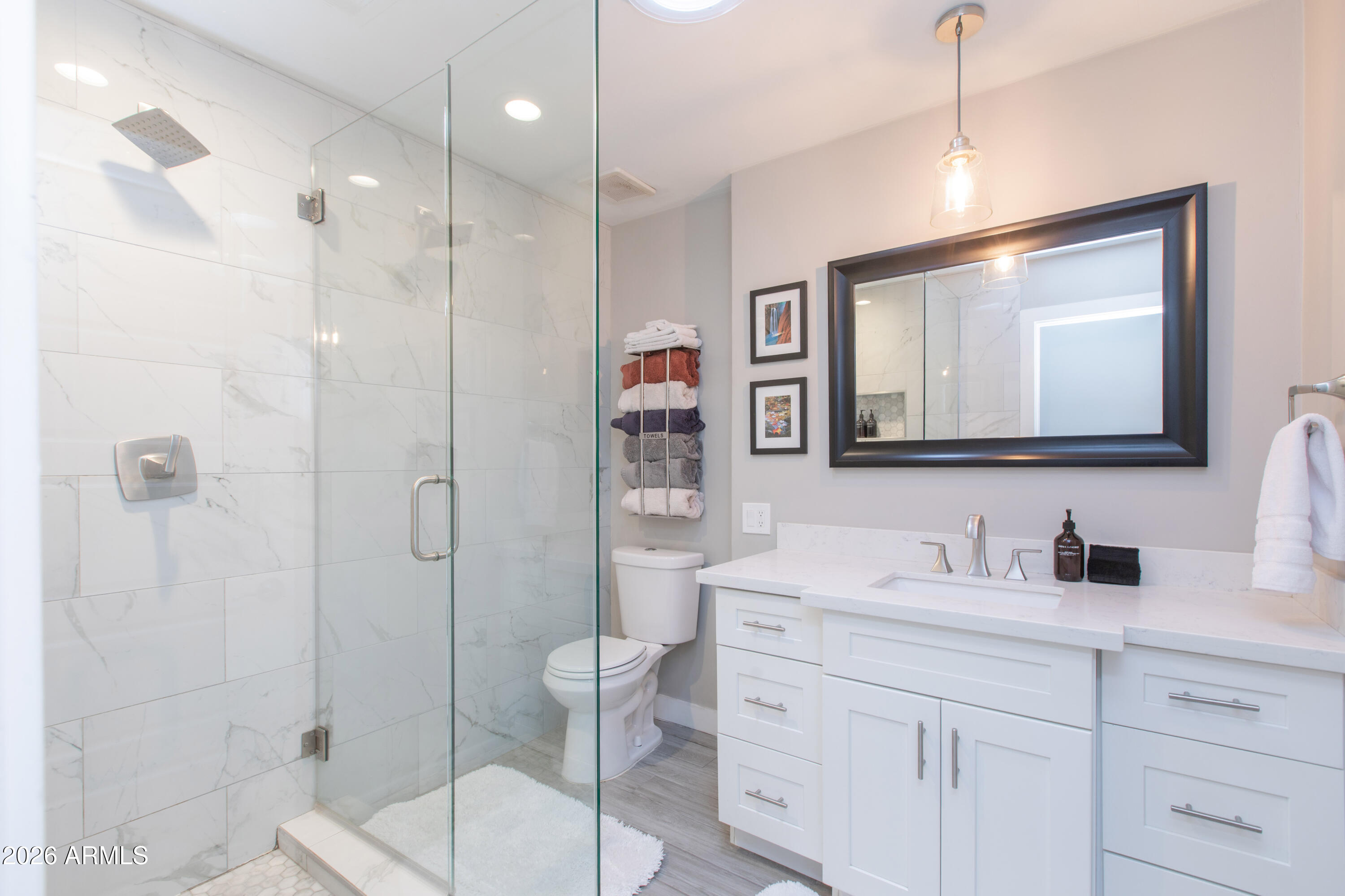5541 East Cheery Lynn Road Phoenix, AZ 85018 - Photo 32 of 69 a bathroom with a toilet a sink a glass door a shower a mirror and vanity