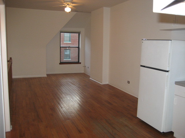 Undisclosed Address Chicago, IL 60607 - Photo 2 of 8 a view of an empty room with wooden floor and a window
