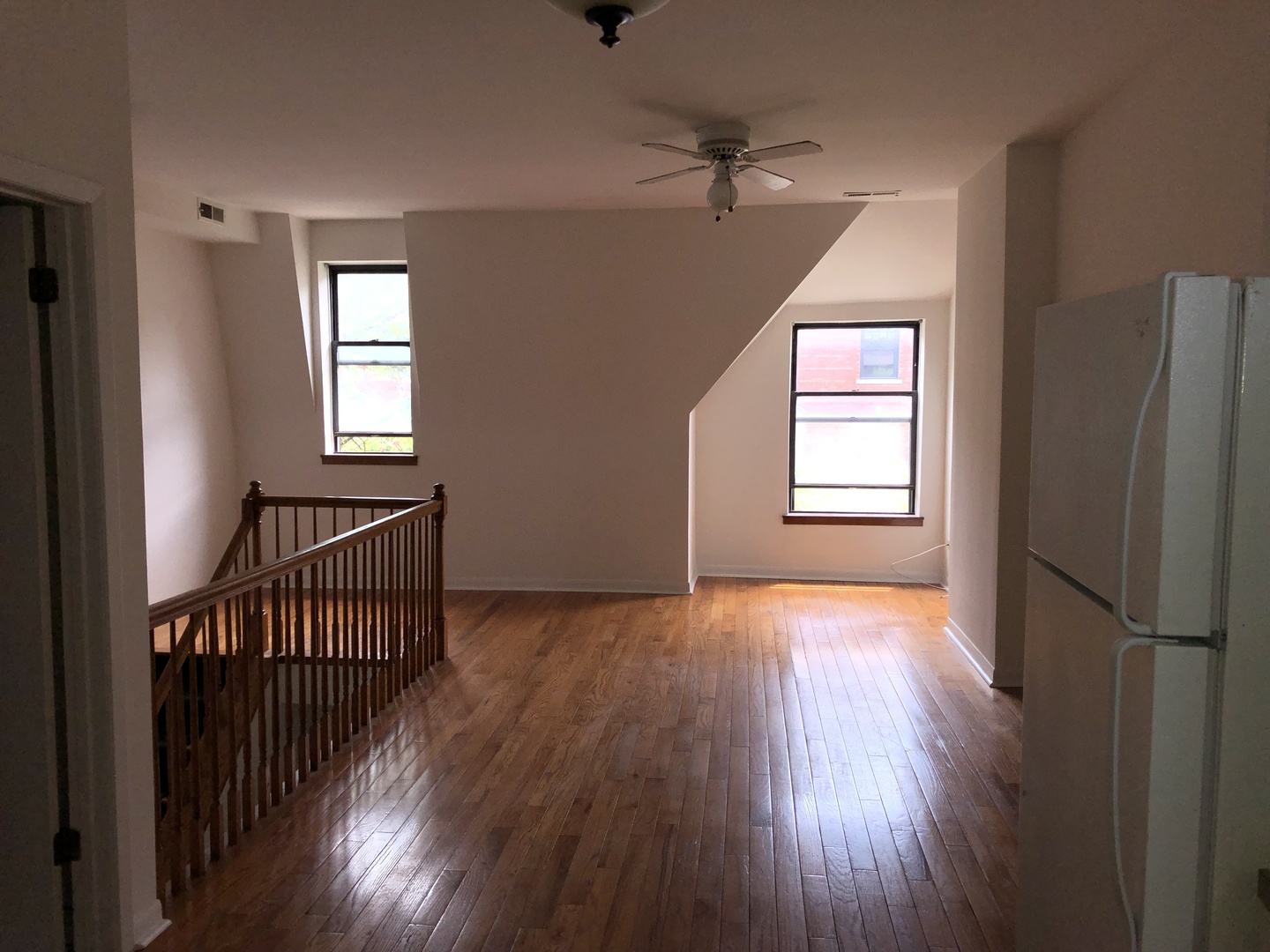 Undisclosed Address Chicago, IL 60607 - Photo 5 of 8 an empty room with wooden floor a ceiling fan and windows