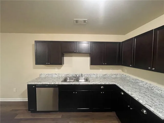 a bathroom with a granite countertop double vanity and a sink