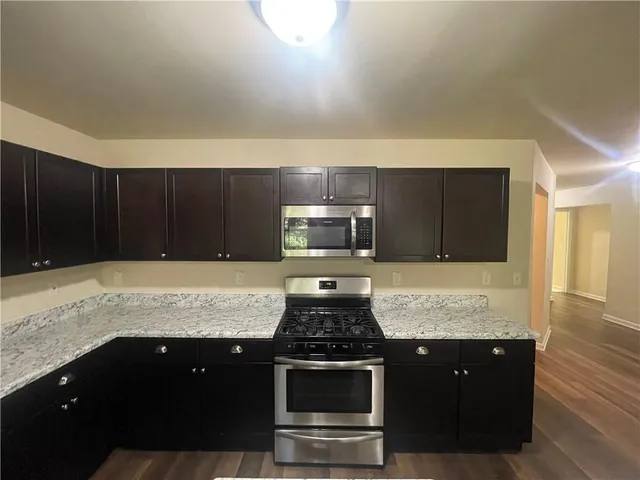 a kitchen with granite countertop stainless steel appliances and wooden cabinets