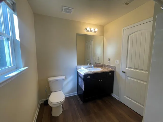 a bathroom with a toilet sink and mirror