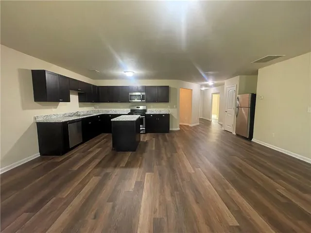 a large kitchen with a counter space a sink and stainless steel appliances