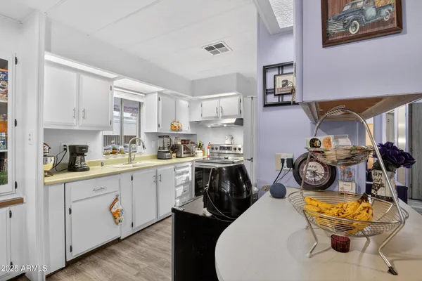 a kitchen with stainless steel appliances granite countertop a stove and white cabinets