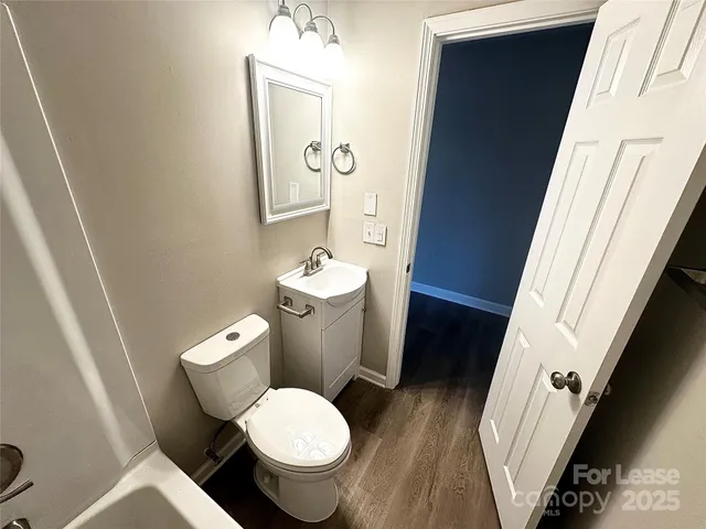 a white toilet sitting next to a sink and a mirror
