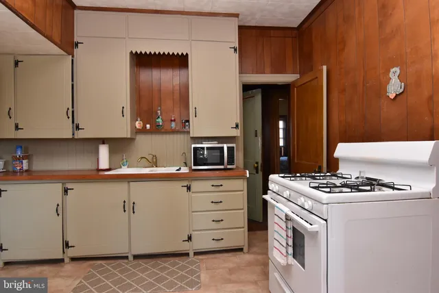 a kitchen with granite countertop a sink cabinets and stainless steel appliances