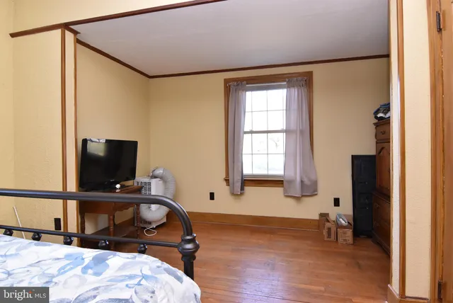 a bedroom with a bed window and a table