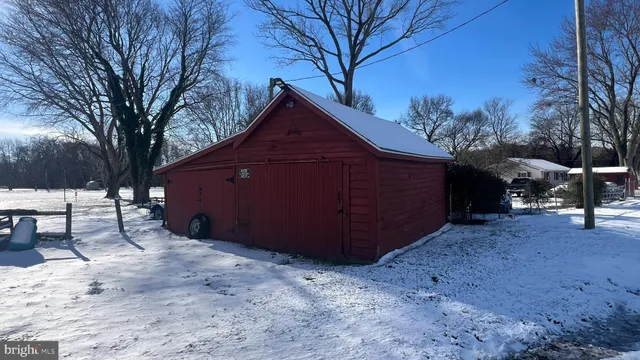 a view of a house with a yard covered with snow in the forest