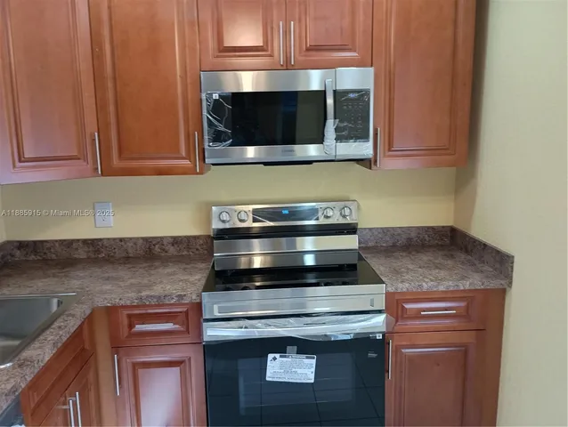 a kitchen with stainless steel appliances granite countertop a stove and a microwave