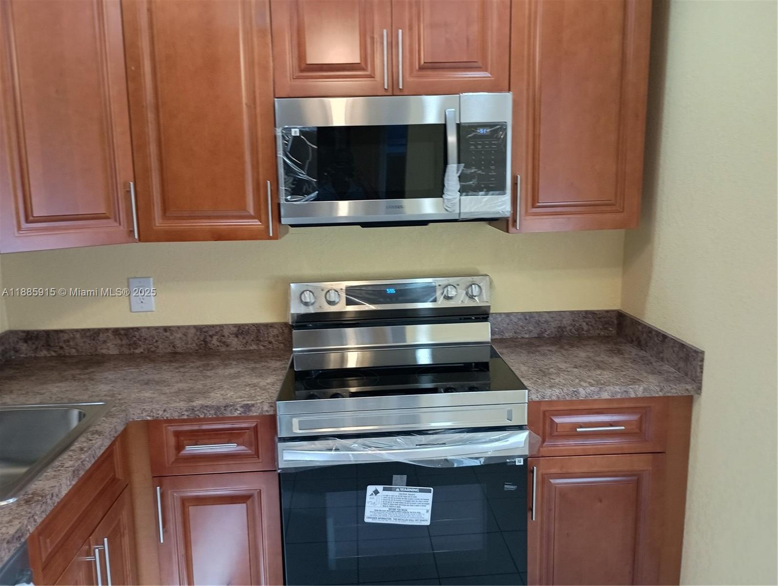 3531 Inverrary Drive, Unit 206 Lauderhill, FL 33319 - Photo 3 of 4 a kitchen with stainless steel appliances granite countertop a stove and a microwave