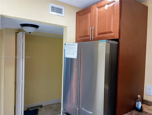 a view of a refrigerator in kitchen
