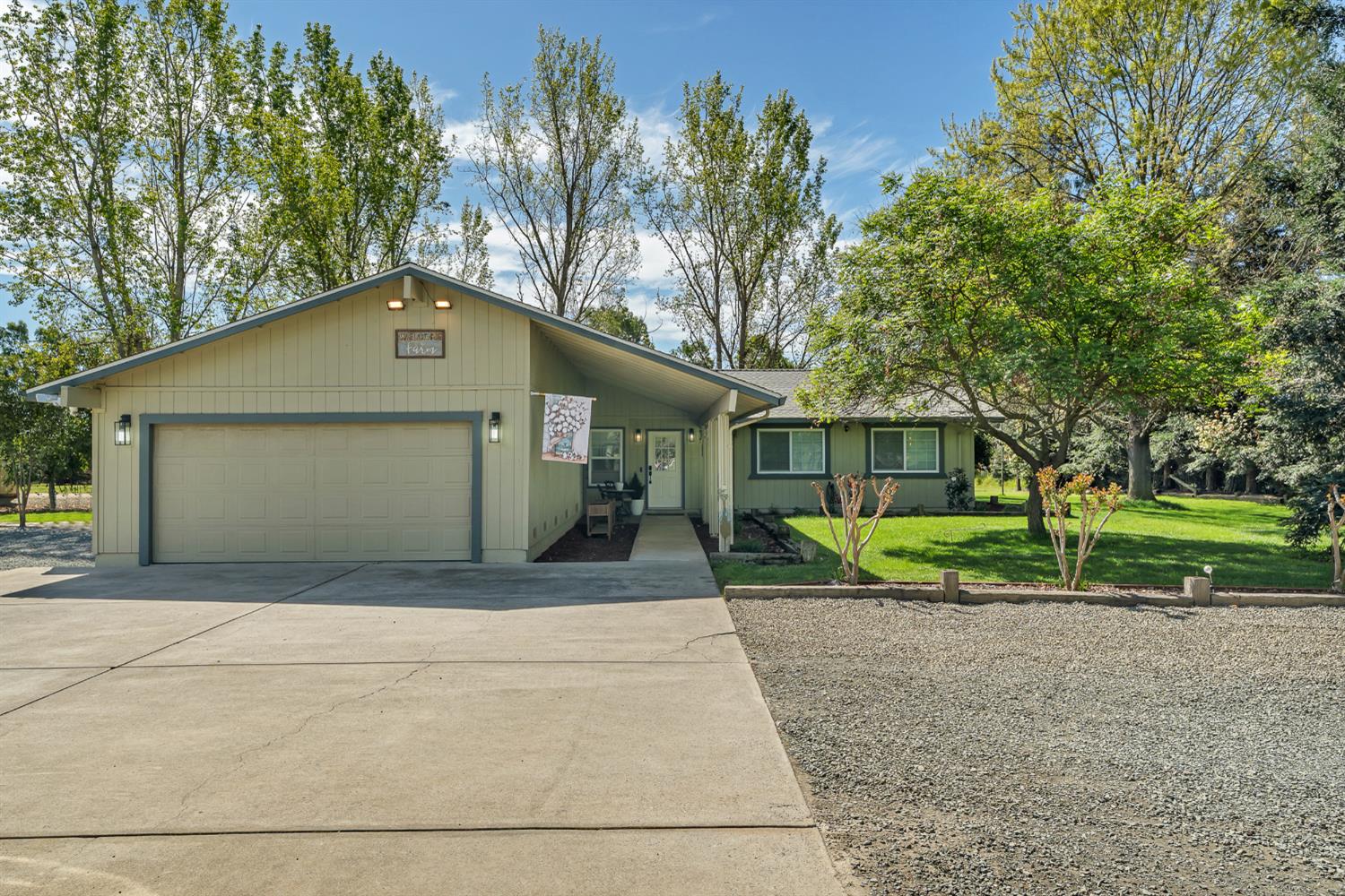 view of front of house with an attached garage, concrete driveway, and a front yard