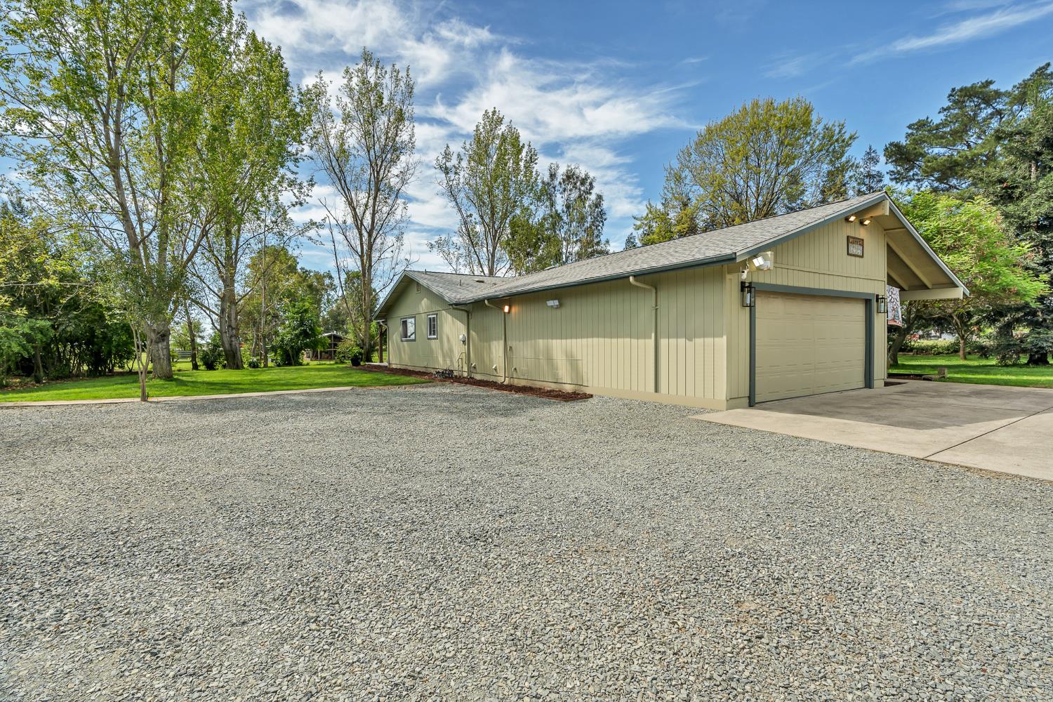 12354 Hobday Road Wilton, CA 95693 - Photo 3 of 77 view of property exterior featuring concrete driveway, a lawn, an attached garage, and a shingled roof